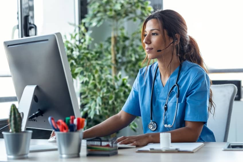 Shot of female doctor talking with earphone while explaining medical treatment to patient through a video call with computer in the