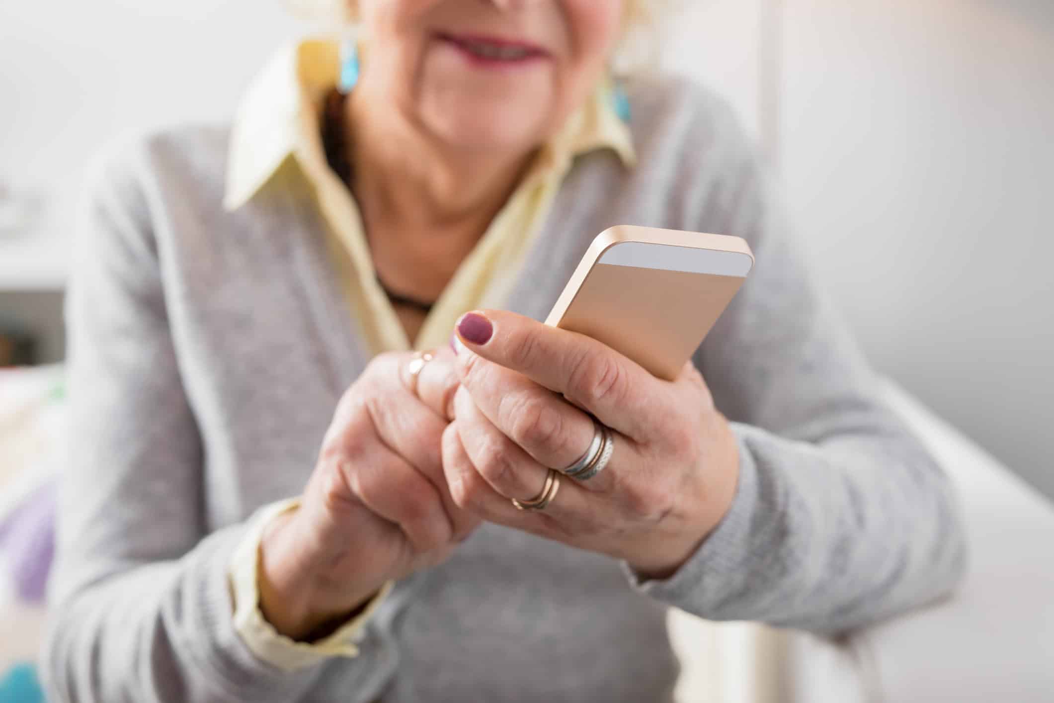Senior woman holding smartphone in hands