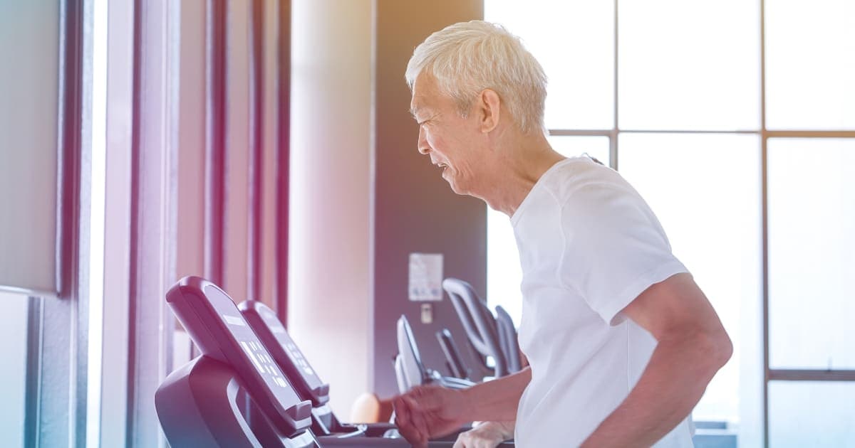 Old healthy Asian senior couple exercise together in gym running treadmill