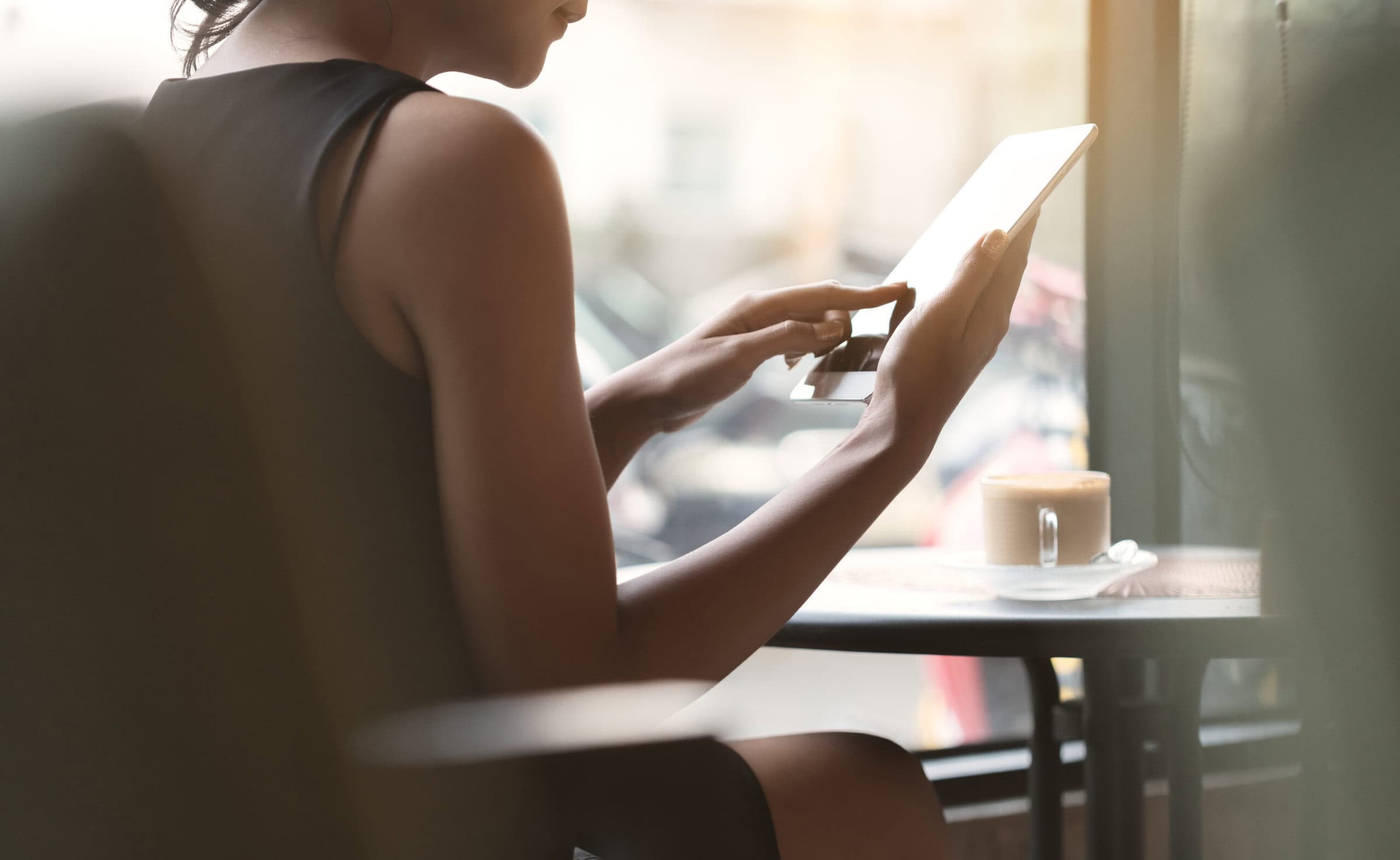 Woman,Using,Tablet,In,Coffee,Shop Woman,Using,Tablet,In,Coffee,Shop